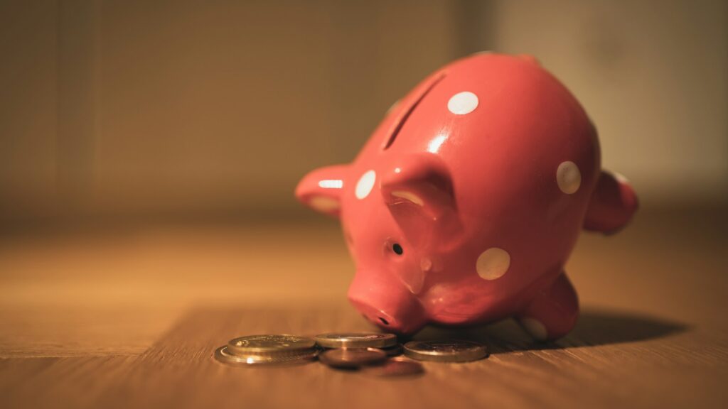 pink pig coin bank on brown wooden table