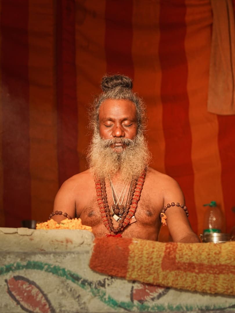 Man with long beard meditating with eyes closed meditating.