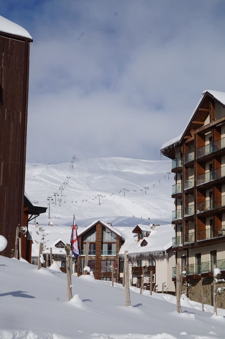 a snow covered ski slope next to a building
